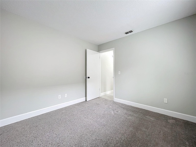 carpeted spare room featuring a textured ceiling