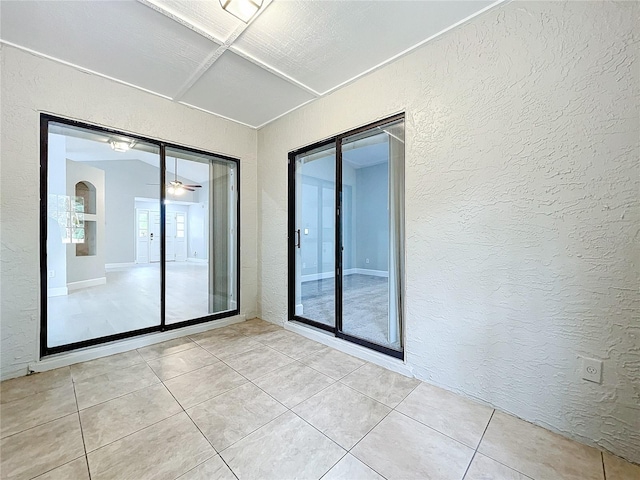 unfurnished room with light tile patterned floors and ceiling fan