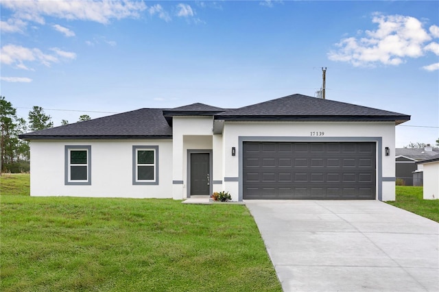 prairie-style home with a garage and a front lawn