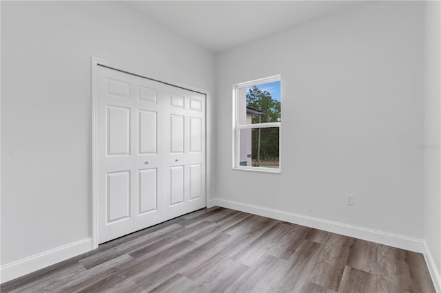 unfurnished bedroom with a closet and light wood-type flooring