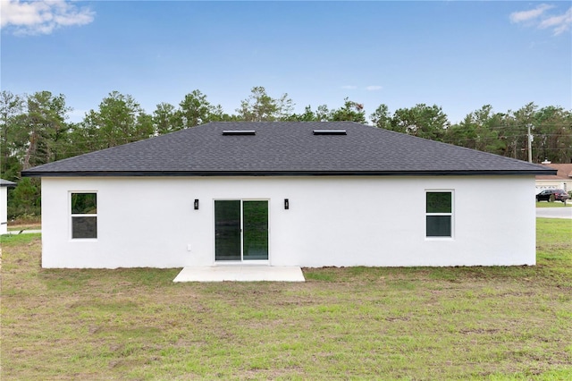 rear view of property featuring a lawn and a patio