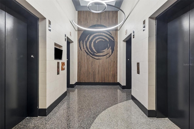 hallway featuring elevator and a package area