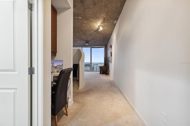 hallway featuring light colored carpet and a wall of windows