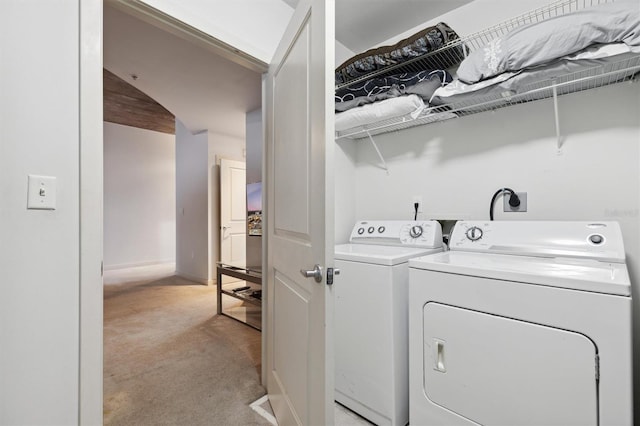 clothes washing area with washing machine and dryer and light colored carpet