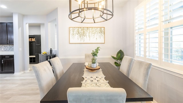 dining space featuring an inviting chandelier and light wood-type flooring