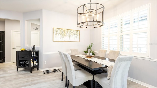 dining area featuring a chandelier, a wealth of natural light, and light hardwood / wood-style flooring