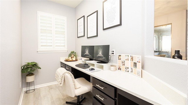 office featuring light hardwood / wood-style flooring and built in desk