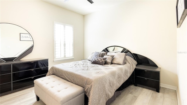 bedroom featuring ceiling fan, multiple windows, and light hardwood / wood-style flooring