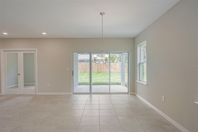 unfurnished dining area with light tile patterned floors and an inviting chandelier