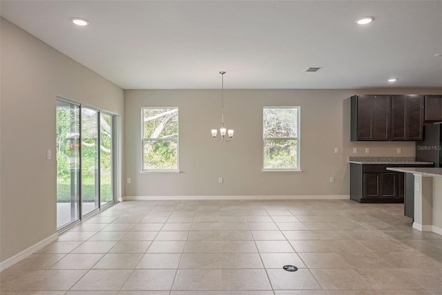 kitchen with dark brown cabinets, plenty of natural light, pendant lighting, and light tile patterned flooring