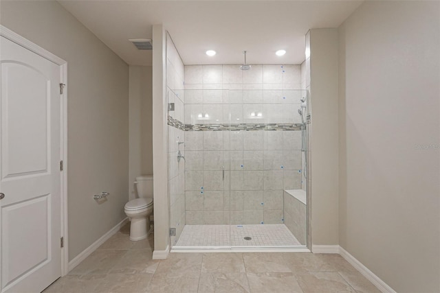 bathroom featuring toilet and a shower with shower door