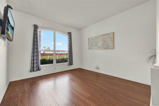 spare room featuring a textured ceiling and hardwood / wood-style flooring