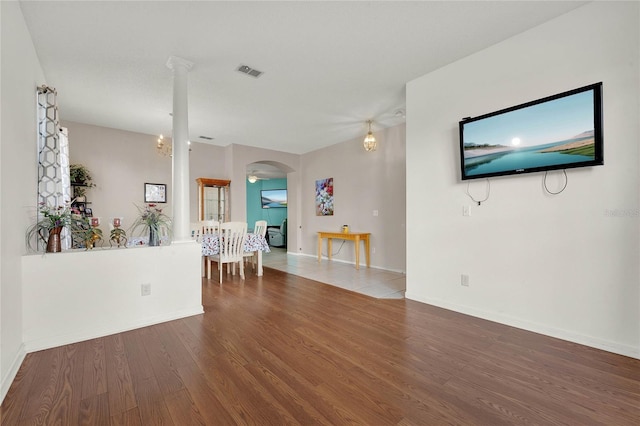 unfurnished living room featuring hardwood / wood-style floors and ceiling fan with notable chandelier