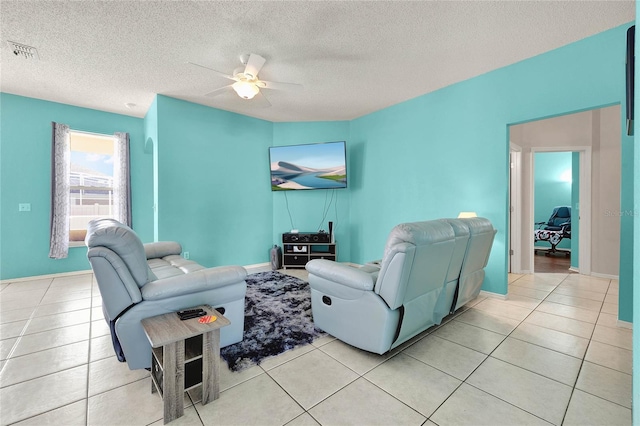 living room featuring light tile patterned floors, a textured ceiling, and ceiling fan