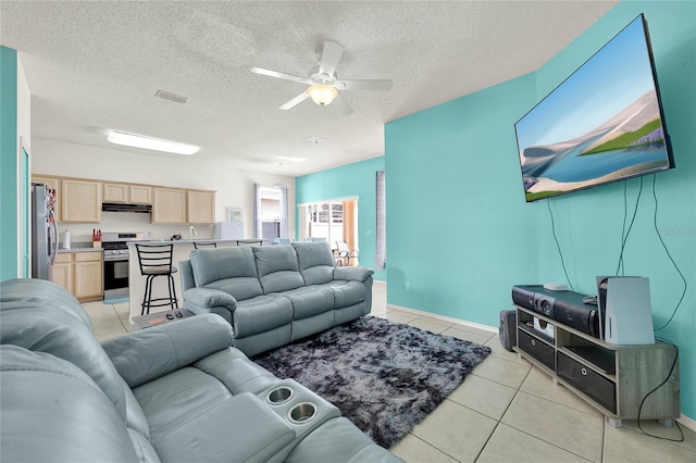 tiled living room with ceiling fan and a textured ceiling