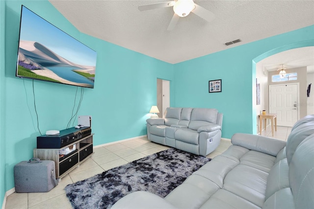 living room featuring a textured ceiling, ceiling fan, and light tile patterned flooring