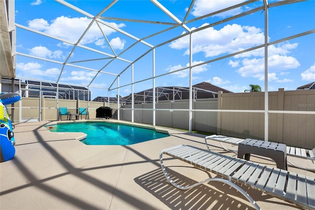 view of pool featuring glass enclosure and a patio area