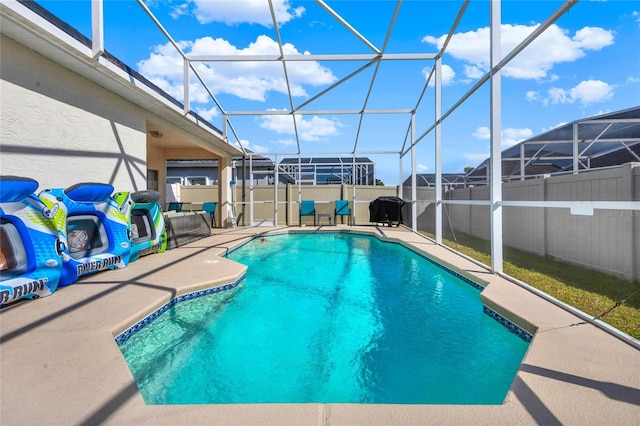 view of swimming pool featuring glass enclosure and a patio area