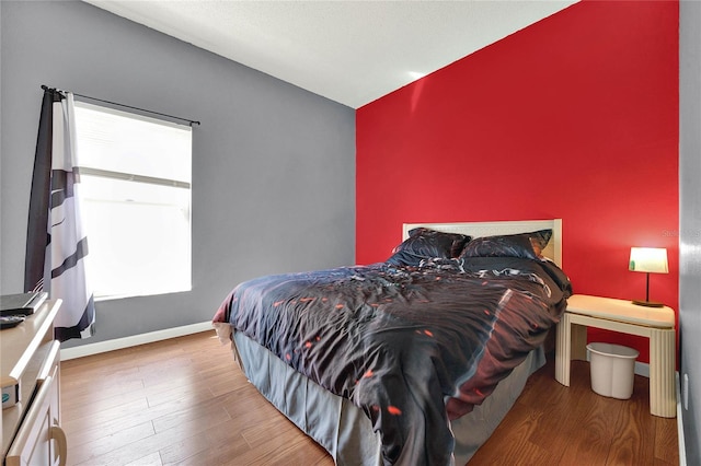 bedroom with hardwood / wood-style floors and multiple windows