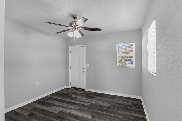 empty room with a textured ceiling, ceiling fan, and dark wood-type flooring