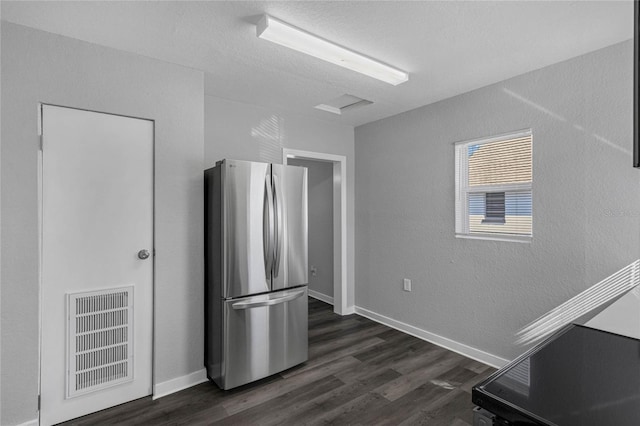 kitchen with stainless steel fridge and dark hardwood / wood-style flooring