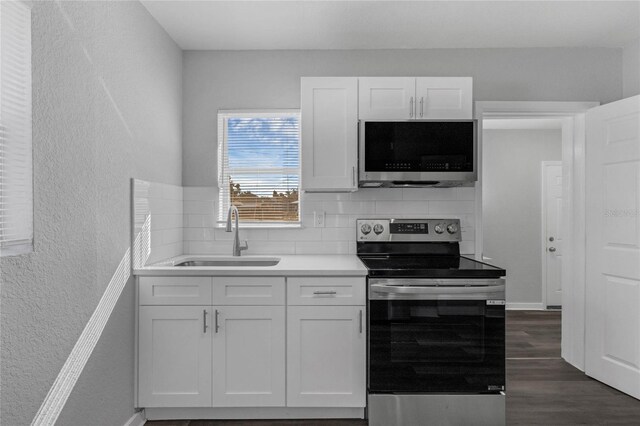 kitchen featuring appliances with stainless steel finishes, dark hardwood / wood-style flooring, tasteful backsplash, sink, and white cabinetry