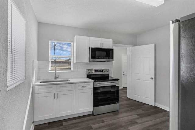 kitchen featuring sink, white cabinetry, stainless steel appliances, and dark wood-type flooring