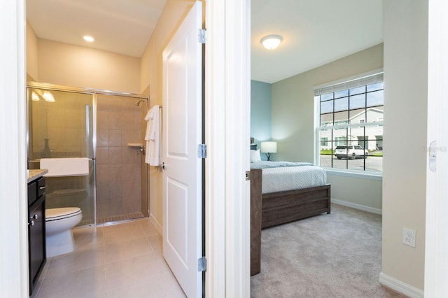 bathroom featuring tile patterned flooring, toilet, vanity, and walk in shower