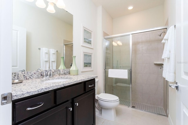 bathroom featuring tile patterned flooring, vanity, toilet, and a shower with door