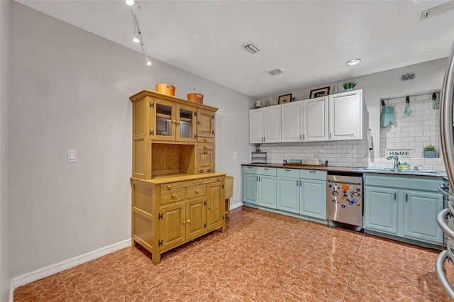 kitchen with dishwasher, white cabinets, rail lighting, sink, and tasteful backsplash