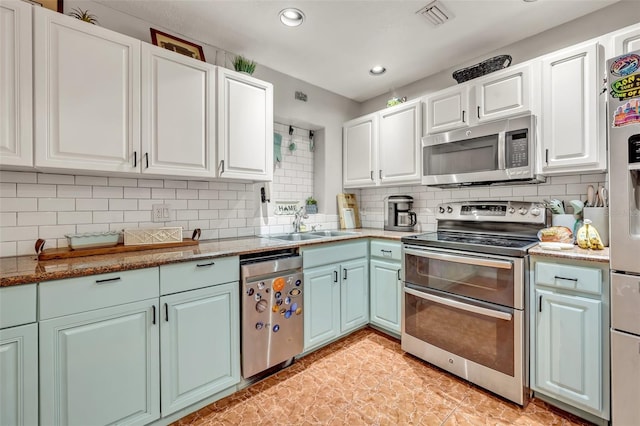 kitchen featuring white cabinets, decorative backsplash, stainless steel appliances, and sink