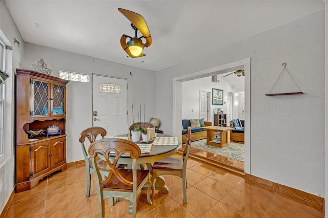 tiled dining space with ceiling fan