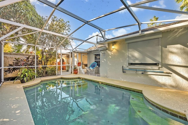 view of swimming pool featuring a patio and glass enclosure