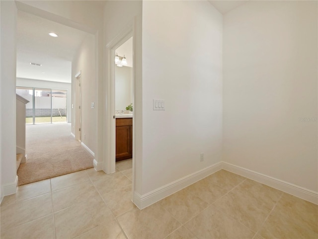 hallway with light colored carpet