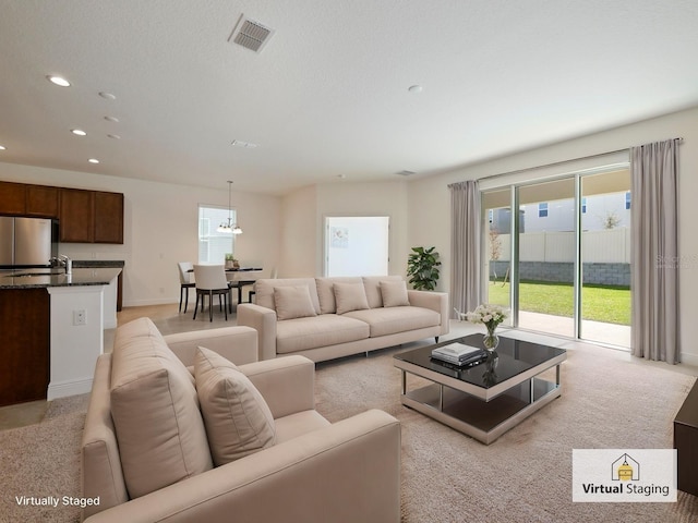 living room featuring light carpet and a textured ceiling