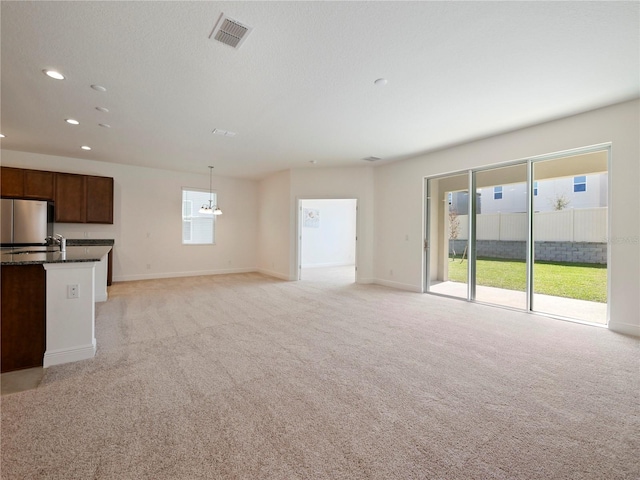 unfurnished living room featuring light colored carpet