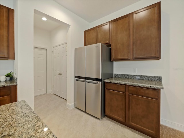 kitchen featuring stone counters and stainless steel fridge