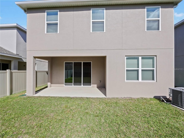 rear view of house with cooling unit, a patio area, and a yard