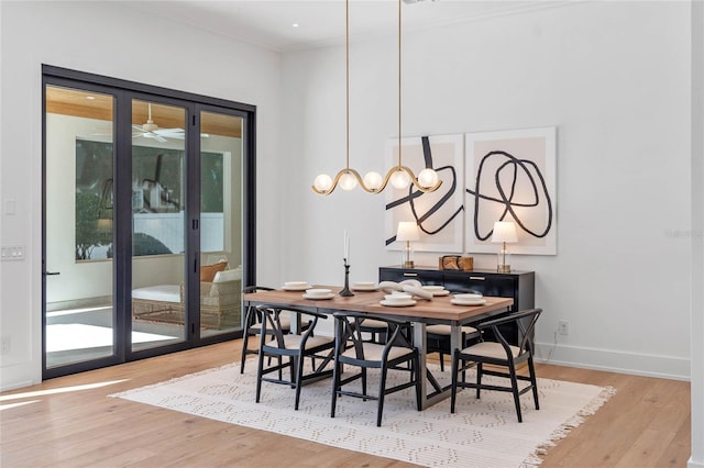 dining area with plenty of natural light, light wood-style flooring, baseboards, and ornamental molding