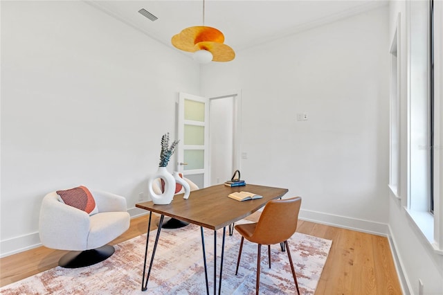 office space featuring light wood finished floors, visible vents, and baseboards