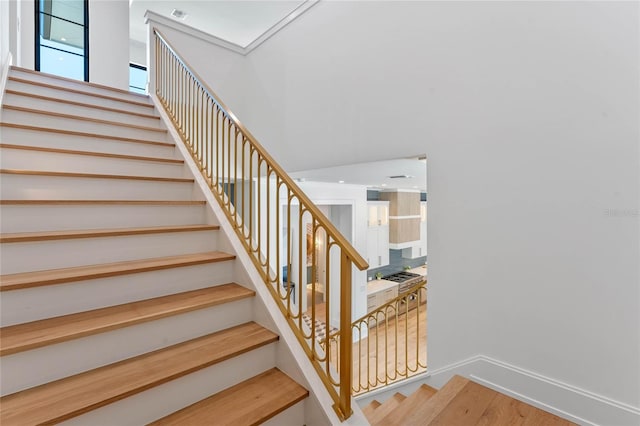 stairway featuring wood finished floors, visible vents, and baseboards