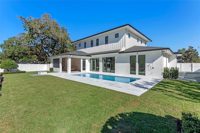 rear view of property featuring a patio area, a lawn, and a fenced backyard