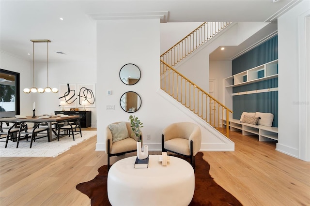 sitting room with stairs, wood finished floors, and baseboards