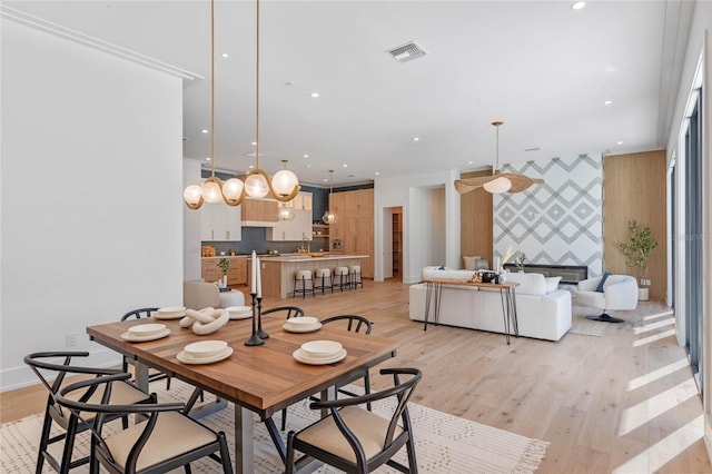 dining room featuring light wood-style flooring, an accent wall, visible vents, and recessed lighting