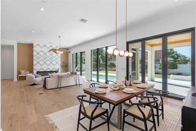 dining room featuring wallpapered walls, an accent wall, french doors, light wood-style floors, and recessed lighting