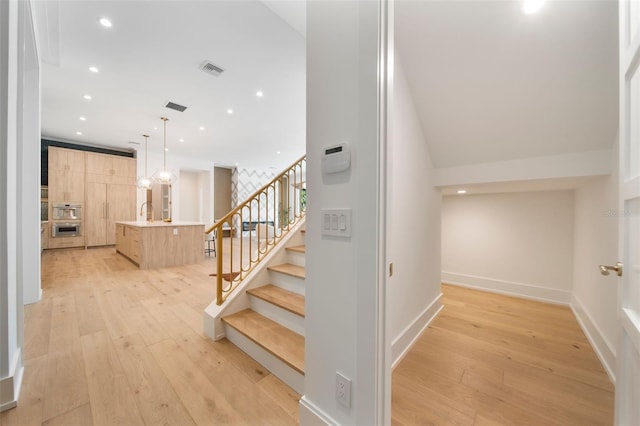 stairs featuring recessed lighting, visible vents, and wood finished floors