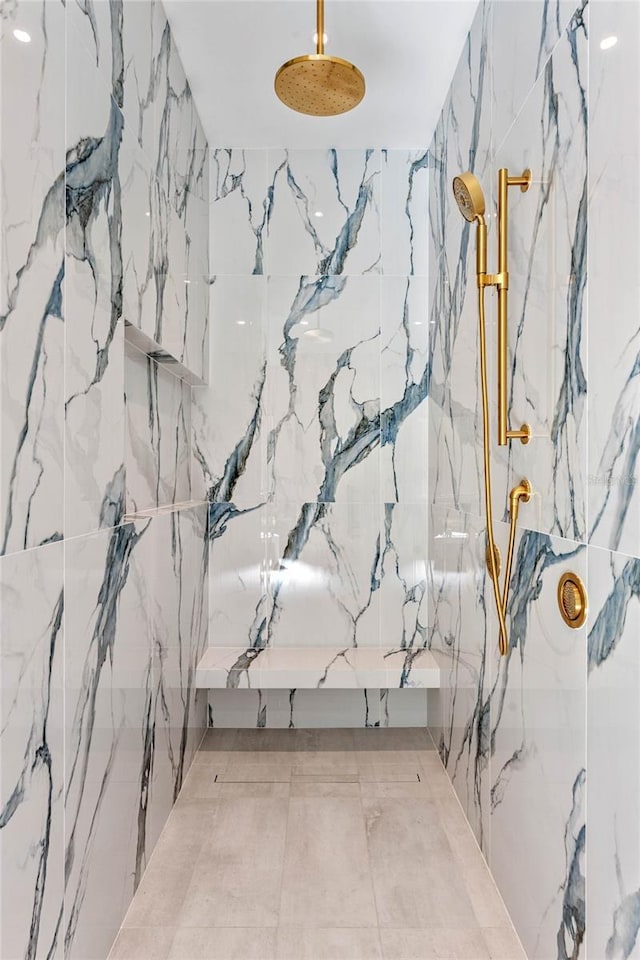 interior space featuring a marble finish shower and stone wall