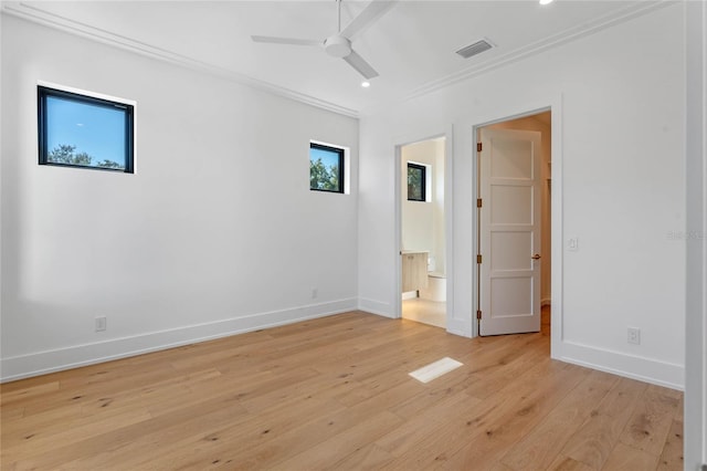 spare room with a ceiling fan, visible vents, light wood-style flooring, and baseboards