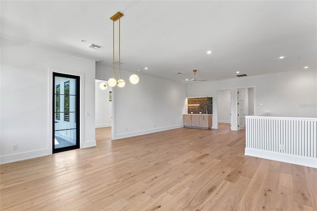 unfurnished living room featuring baseboards, ornamental molding, visible vents, and light wood-style floors