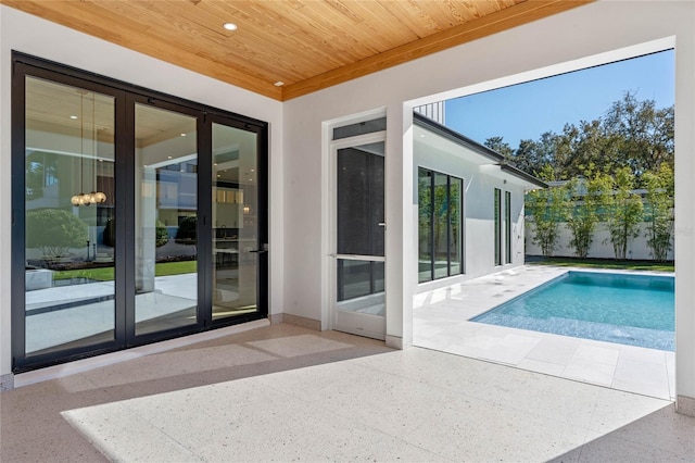 exterior space featuring light speckled floor, baseboards, wood ceiling, and recessed lighting